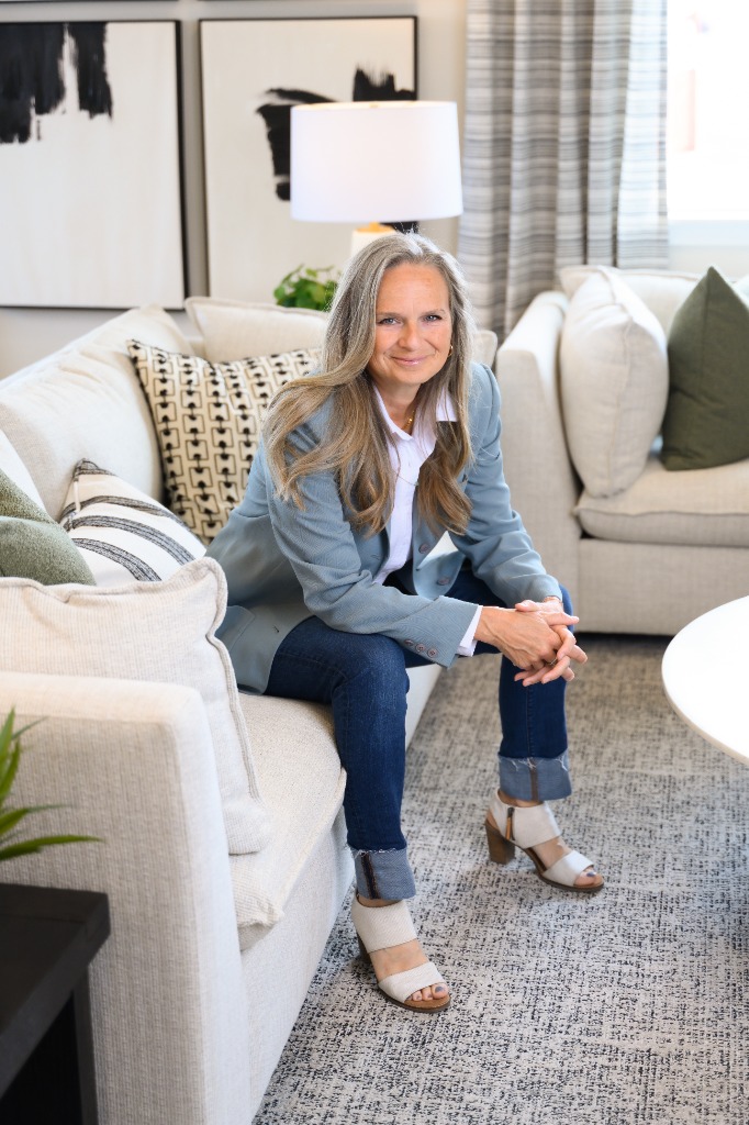 Alicia seated in a model home living room